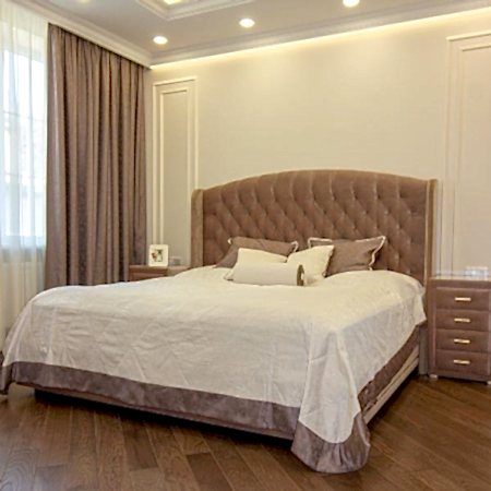 Шторы в спальню с покрывалом и подушками коричневого цвета